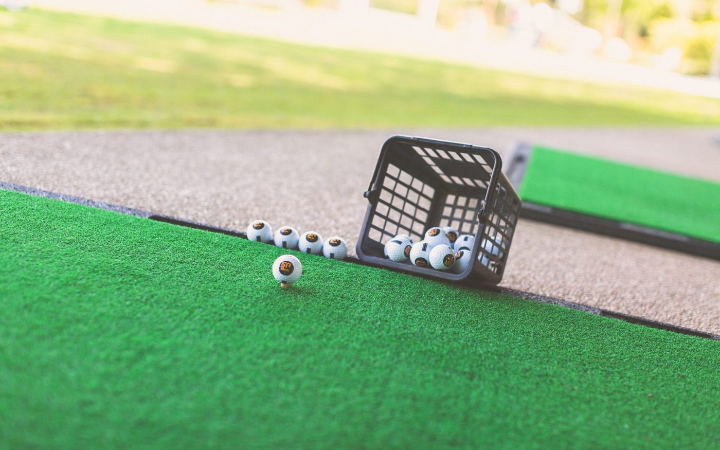 Les tapis du practice de Biot avec un panier de balles